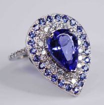 A white metal, tanzanite and diamond pear shaped cluster ring, featuring a centre pear cut tanzanite