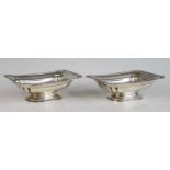 A pair of silver pedestal butter dishes, each having gadrooned rim with shell capped corners,