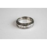 A white metal diamond half eternity ring, comprising a centre row of 18 baguette cut diamonds in