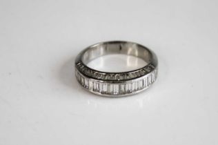 A white metal diamond half eternity ring, comprising a centre row of 18 baguette cut diamonds in