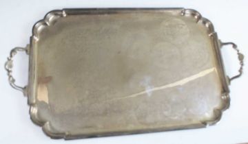 A large and heavy Elizabeth II silver twin handled serving tray, of shaped rectangular form with