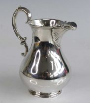 A Victorian silver cream jug, the pear shape plain body with reeded rims, having S-scroll handle and