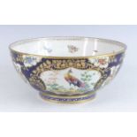 A Worcester style bowl, 19th century, decorated with cartouches of birds and flowers upon a blue