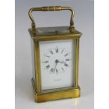 A late 19th century French lacquered brass cased carriage clock, the white enamel Roman dial