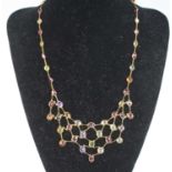 A yellow metal multi-stone fringe necklace, featuring garnet, tourmaline, peridot, citrine,
