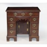 A George III mahogany kneehole desk, having an arrangement of seven drawers above a kneehole