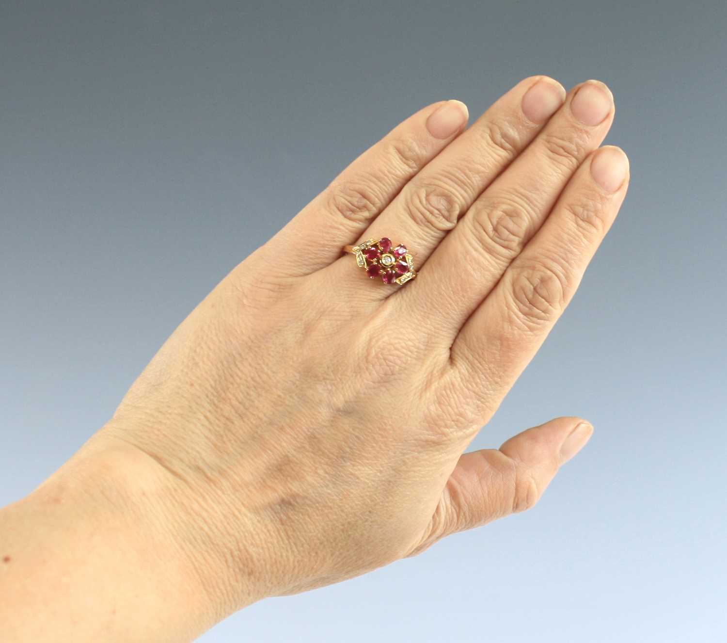 An 18ct yellow and white gold ruby and diamond oval cluster ring, featuring a centre oval facetted - Image 7 of 7