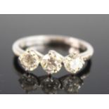 An 18ct white gold diamond trilogy ring, comprising three round brilliant cut diamonds in