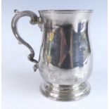 A George II silver bell shape tankard, having plain baluster body with gilt-washed interior and