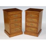 A pair of oak four drawer bedside chests, each having a brushing slide, the graduated drawers with