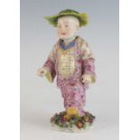 A Meissen porcelain nodding figure of a Chinese marching boy, 19th century, shown wearing a leaf hat