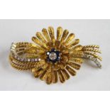 An 18ct yellow gold, sapphire and diamond stylised flower brooch, featuring a central cluster of a