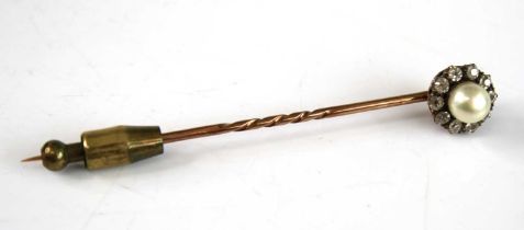 A yellow metal, pearl and diamond stick pin, having a centre 5.9mm cultured pearl within a border of