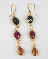 A pair of yellow metal multi-sapphire drop earrings, each with two oval and one pear cut sapphire,