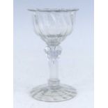 A champagne glass, circa 1745, the wrythen moulded ogee bowl having an everted rim above an eight