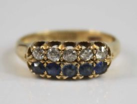 A late Victorian 18ct yellow gold, sapphire and diamond half eternity ring, comprising a row of five