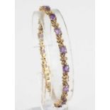 A modern 9ct gold, amethyst and diamond point set bracelet, comprising 15 x 4 claw set oval