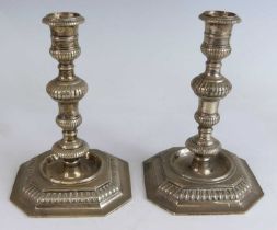 A pair of Elizabeth II silver candlesticks in the Georgian style, the stems of knopped reeded form