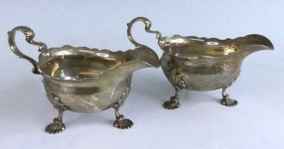 A pair of George II silver sauceboats, each of plain oval form with shaped rims and scrolling