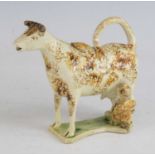 A Staffordshire or Yorkshire pearlware cow creamer, circa 1800, shown standing with milkmaid, sponge