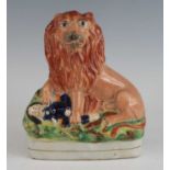 A Staffordshire model of the British lion over Napoleon III, circa 1860, the lion shown with paws