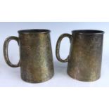 A pair of Egyptian white metal tankards, of stein form with plain applied C handles, all-over