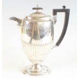 A late Victorian silver pedestal coffee pot, of slender half-reeded form upon a stepped oval foot,