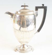 A late Victorian silver pedestal coffee pot, of slender half-reeded form upon a stepped oval foot,