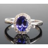 An 18ct white gold, tanzanite and diamond oval cluster ring, featuring a centre oval faceted