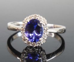 An 18ct white gold, tanzanite and diamond oval cluster ring, featuring a centre oval faceted