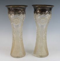 A pair of crystal and silver vases, of waisted form, the silver rims relief decorated with swags and