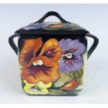 A contemporary Moorcroft Tangerine Pansy pattern pottery twin handled jar and cover, of square