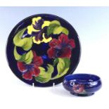 A Moorcroft Hibiscus pattern pottery charger, underglaze painted and tube-line decorated,