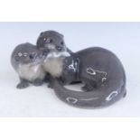 A Royal Copenhagen porcelain model of two otter, each contesting a fish, printed marks and