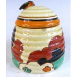 A 1930s Clarice Cliff Farmhouse pattern pottery honey pot and cover, the handle to cover in the form