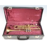 A Boosey and Hawkes model 400 brass trumpet, serial no. 117418, in purple felt lined carry case.