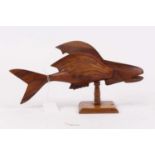 A 20th century Pitcairn Islands carved miro wood model of a flying fish, the left wing carved "