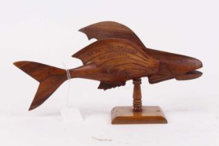 A 20th century Pitcairn Islands carved miro wood model of a flying fish, the left wing carved "