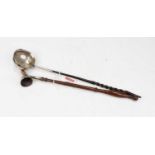 An 18th century white metal toddy ladle, inset with a 1720 silver shilling, on a turned whalebone