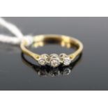 A yellow and white metal diamond three stone ring, the diamonds in illusion settings, total weight
