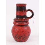 A West German pottery vase, red and black glazed, having single loop handle, h.27cm