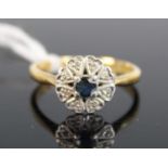 A yellow and white metal, sapphire and diamond circular cluster ring, with centre sapphire and 8