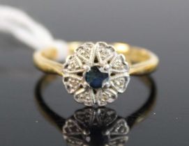 A yellow and white metal, sapphire and diamond circular cluster ring, with centre sapphire and 8