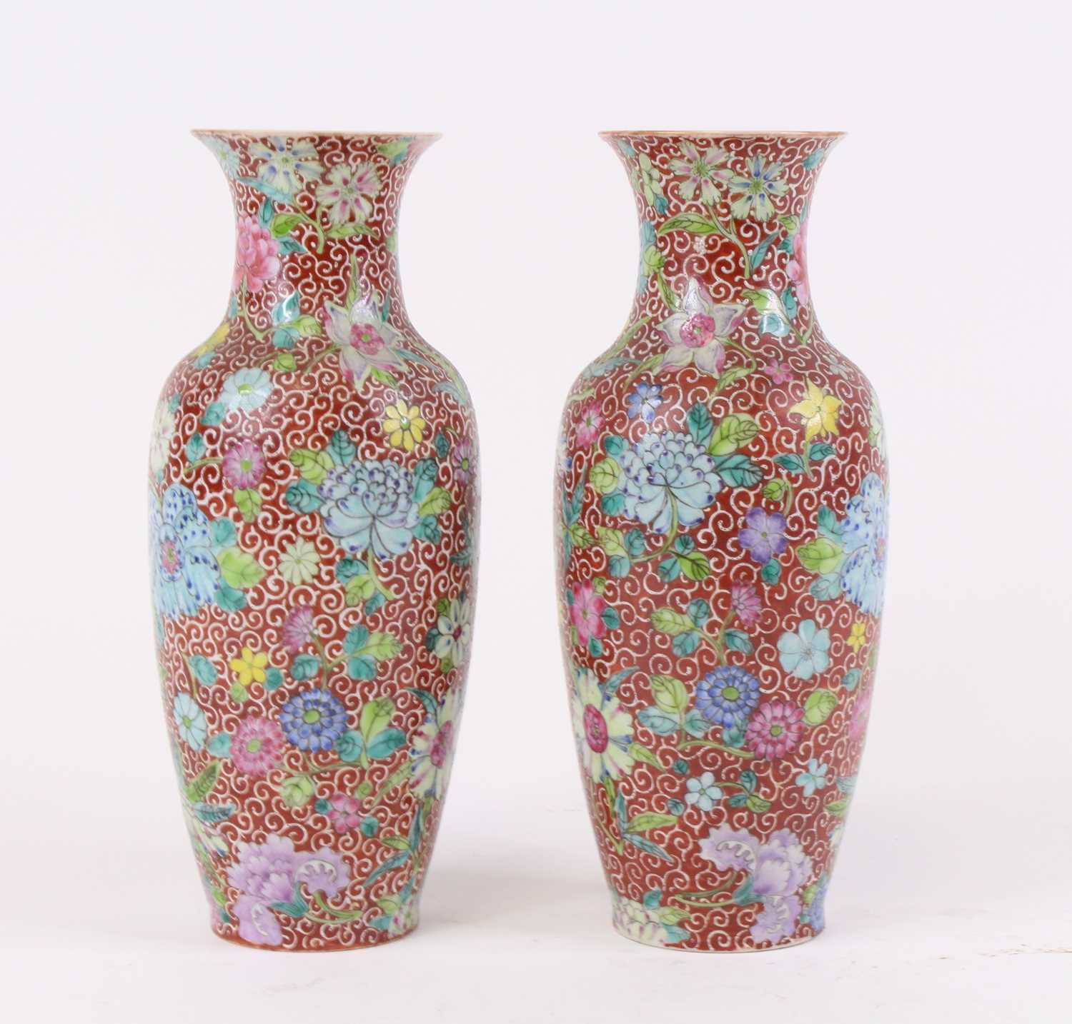 A pair of Chinese porcelain vases, each enamel decorated with flowers, four character seal mark to
