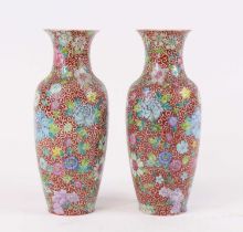 A pair of Chinese porcelain vases, each enamel decorated with flowers, four character seal mark to