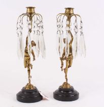 A pair of figural brass table candlesticks, each having cut glass droplets and mounted upon a