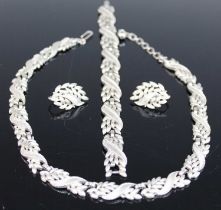 A Trifari white metal suite of jewellery, comprising necklace, bracelet and pair of ear clips,