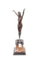 An Art Deco style bronzed figure of a lady, shown with her arms in the air, upon a rouge marble