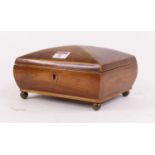 An early 19th century rosewood box, having kite shaped escutcheons standing upon four brass ball