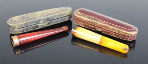 An early 20th century faux amber 9ct gold tipped cheroot holder in fitted leather case, together